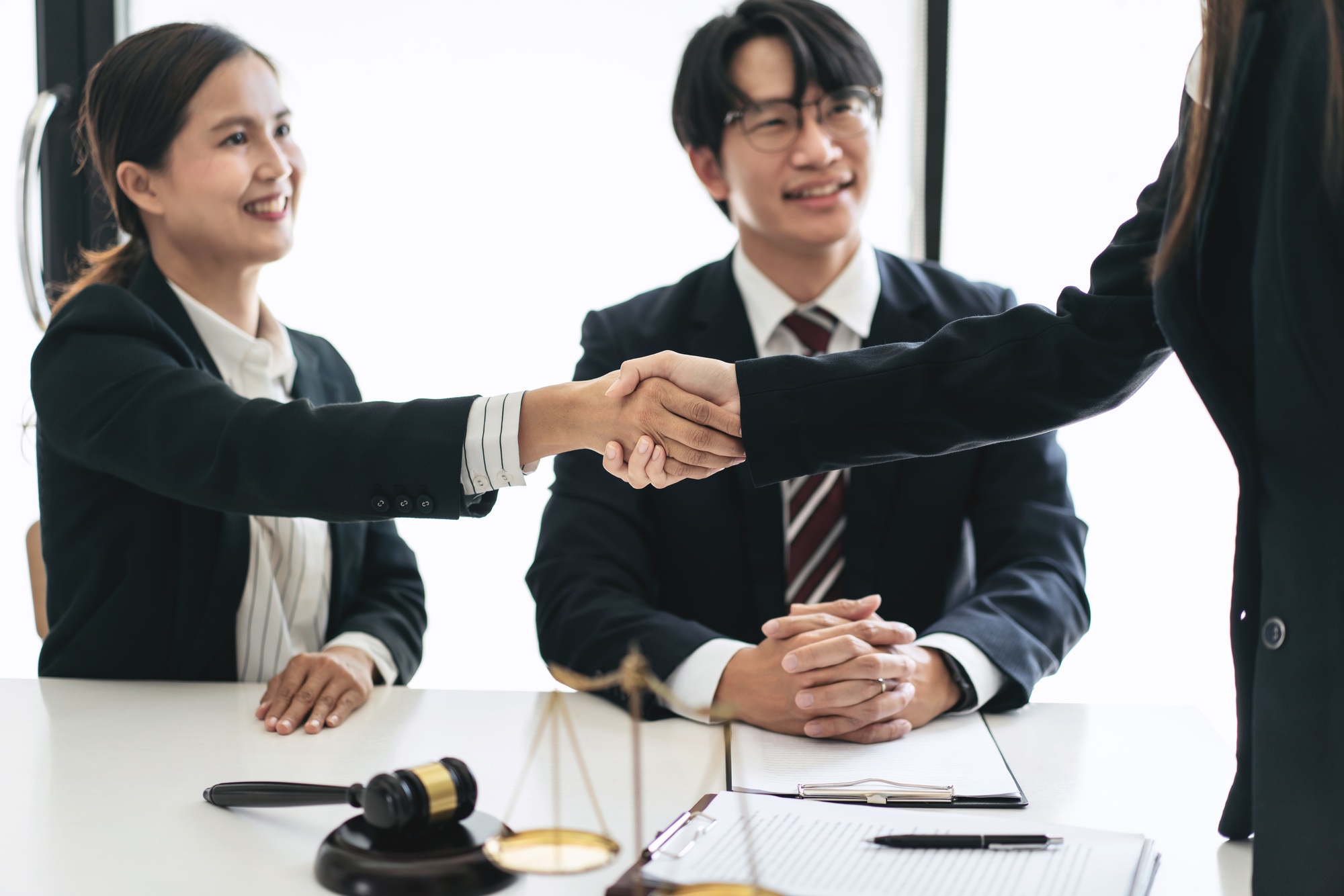 Female lawyer shaking hands with client after discussing deal of